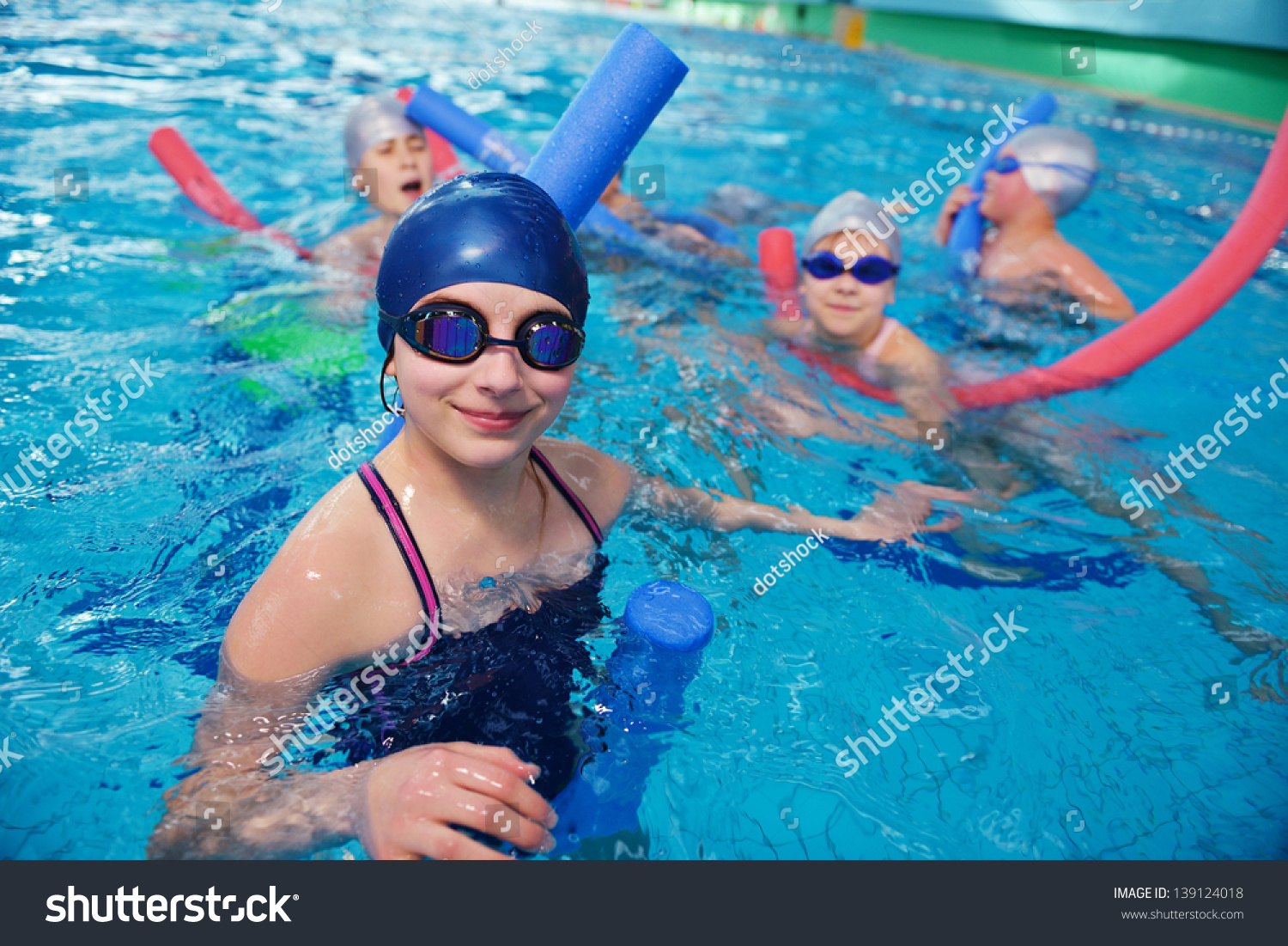 快乐的孩子的孩子在游泳池类学习游泳